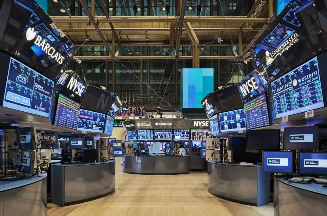 The NYSE trading floor ringed with screens streaming quotes
